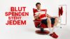 Person in stilvollem rot-weißem Outfit sitzt nach der Blutspende mit Mullbinde am Arm in einem roten Sessel und zeigt nach vorn; daneben steht „Blut spenden steht jedem“.